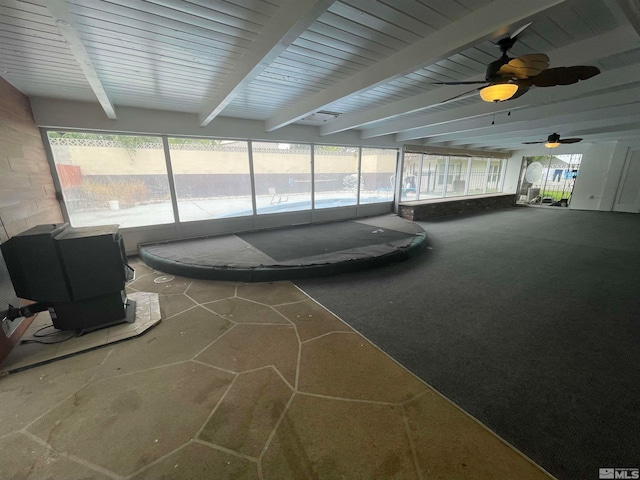 sunroom / solarium with beam ceiling and ceiling fan