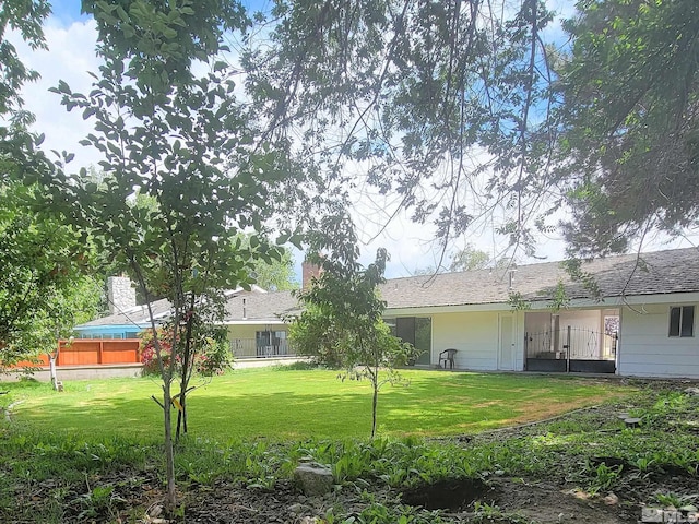 rear view of house featuring a yard