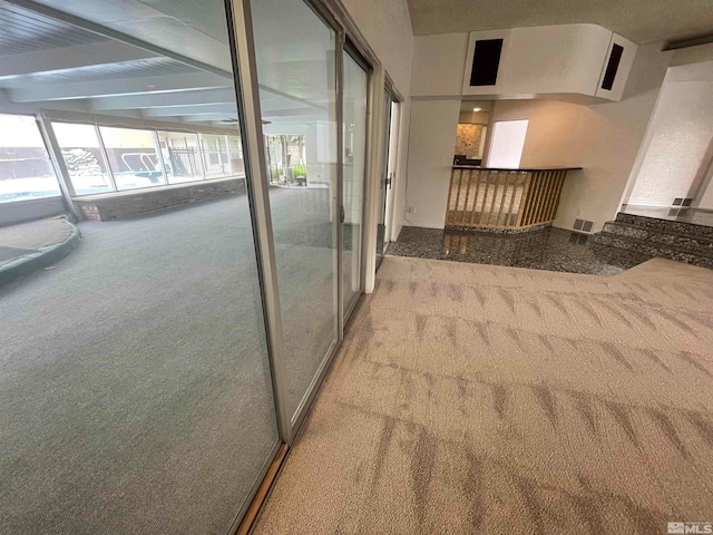 corridor with light carpet and beamed ceiling