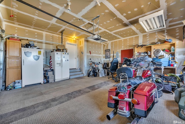 garage featuring white refrigerator with ice dispenser and white fridge