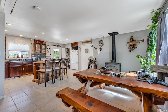 tiled dining room featuring a wood stove