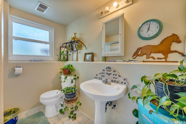 bathroom with toilet and tile floors