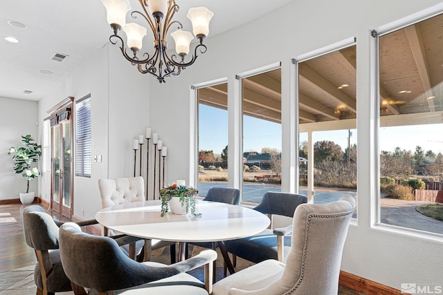 dining area with plenty of natural light, a notable chandelier, and wood-type flooring