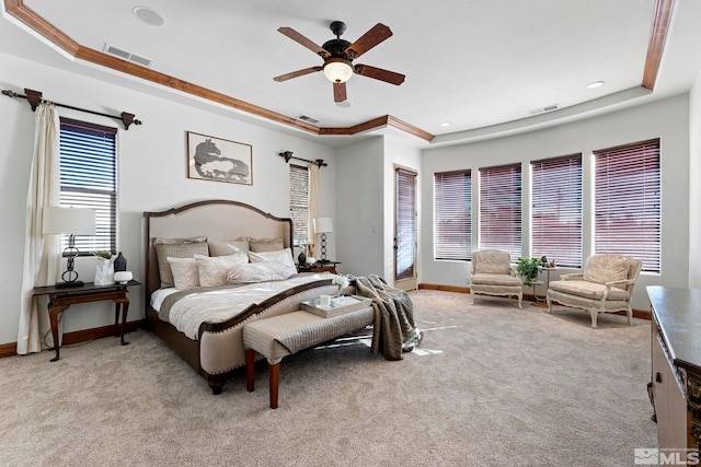 carpeted bedroom featuring ceiling fan, ornamental molding, and a tray ceiling