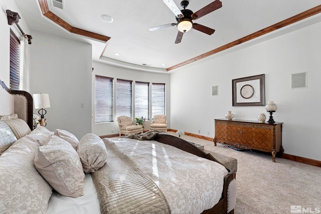 bedroom with ceiling fan, light carpet, and a tray ceiling