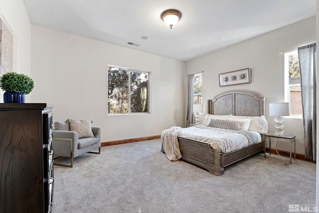 bedroom with multiple windows and light colored carpet