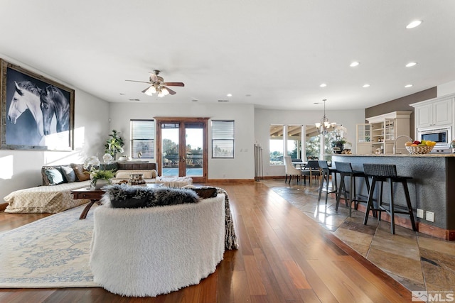 living room featuring hardwood / wood-style floors and ceiling fan with notable chandelier