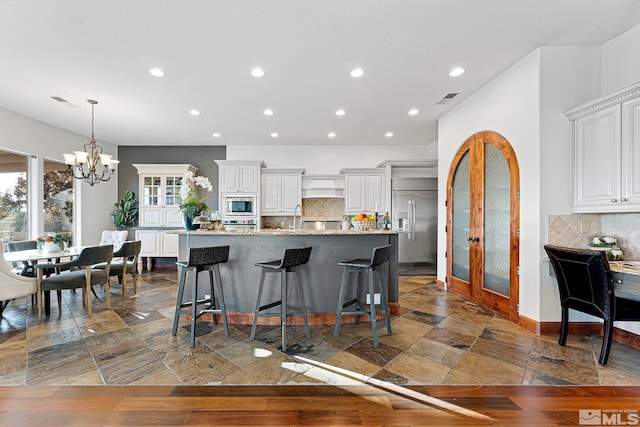 kitchen with tasteful backsplash, a healthy amount of sunlight, and built in appliances