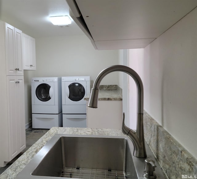 washroom with sink, cabinets, and washer and clothes dryer