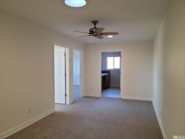 unfurnished bedroom with ceiling fan, connected bathroom, and light colored carpet