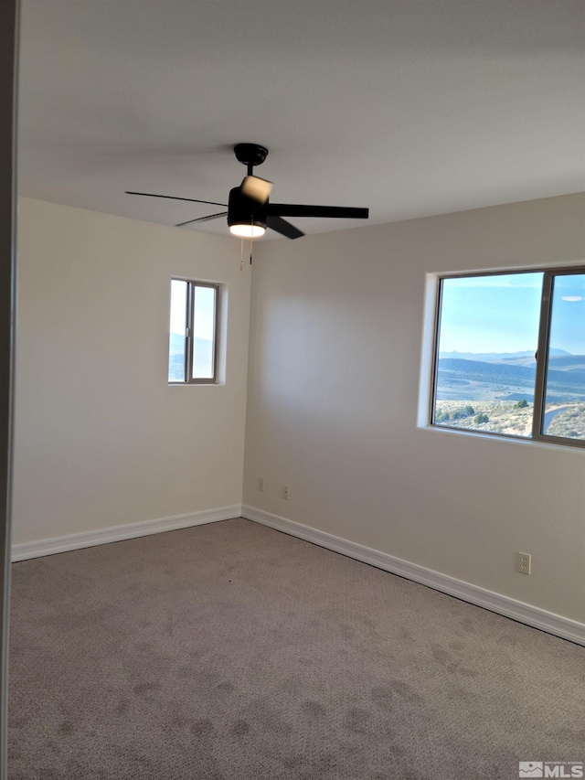 carpeted spare room with ceiling fan