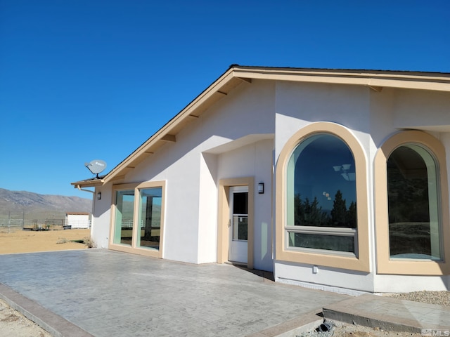 rear view of house with a mountain view and a patio