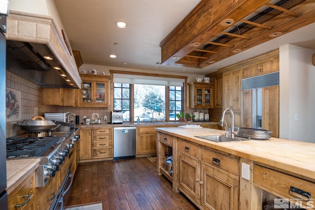 kitchen with wood counters, stainless steel appliances, dark wood-type flooring, backsplash, and sink