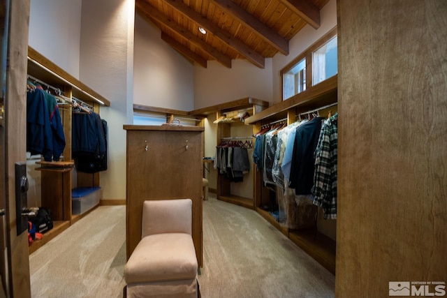 spacious closet featuring beam ceiling, high vaulted ceiling, and light colored carpet