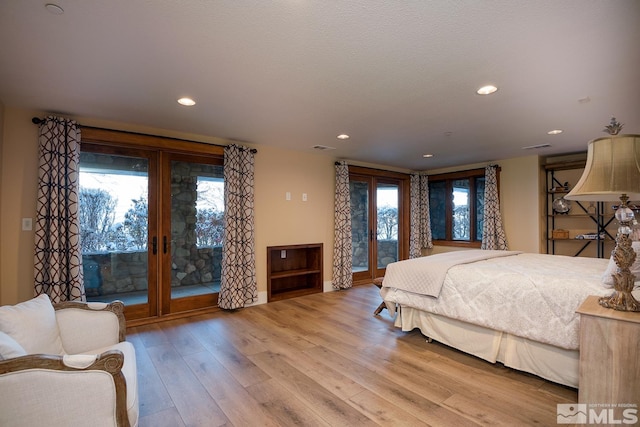 bedroom featuring access to exterior and light wood-type flooring