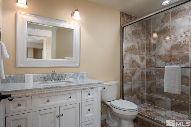 bathroom with tile floors, toilet, walk in shower, and vanity