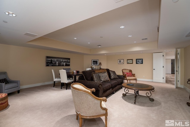 carpeted living room featuring a tray ceiling