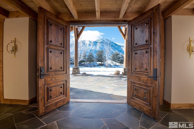 doorway to outside featuring beam ceiling, a mountain view, and wood ceiling