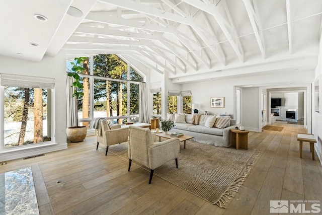 sunroom / solarium featuring vaulted ceiling with beams