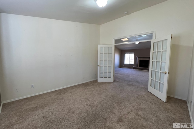 empty room with dark colored carpet and french doors