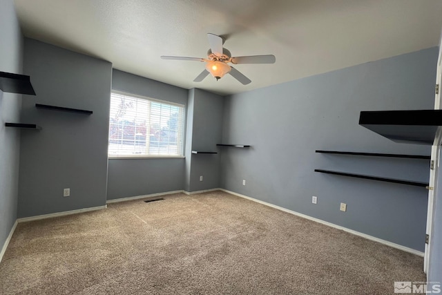 empty room featuring ceiling fan and light colored carpet