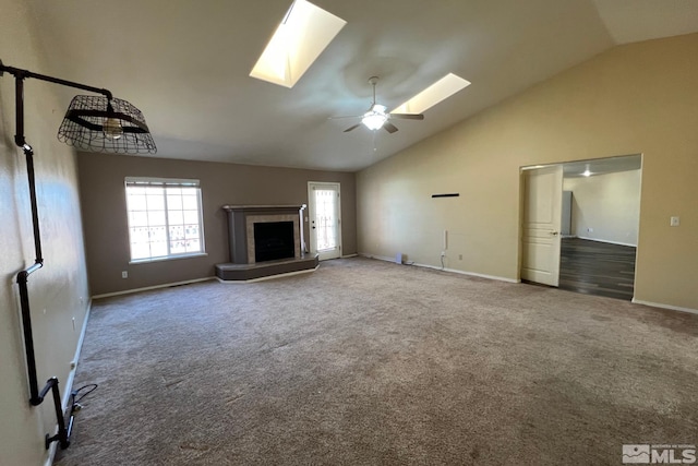 unfurnished living room with high vaulted ceiling, carpet flooring, ceiling fan, and a skylight