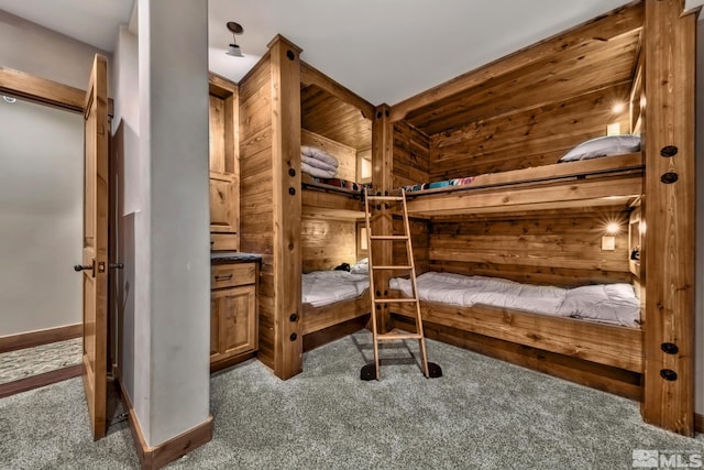 bedroom with wooden walls and carpet floors