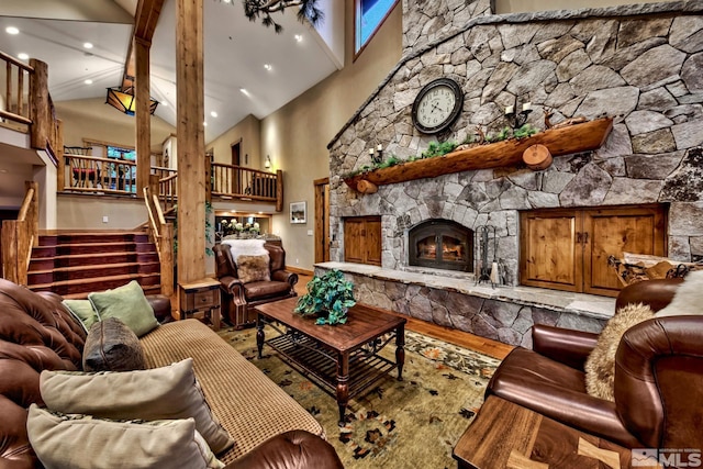 living room with high vaulted ceiling, a fireplace, and wood-type flooring