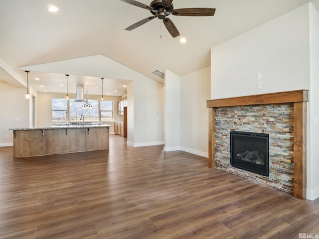 unfurnished living room with ceiling fan, a fireplace, dark hardwood / wood-style floors, and vaulted ceiling