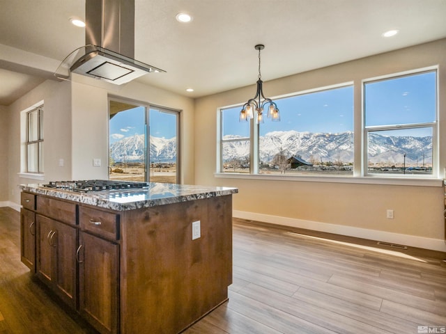 kitchen featuring light hardwood / wood-style floors, a mountain view, a chandelier, and island exhaust hood