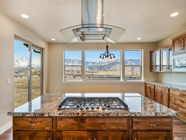 kitchen featuring dark hardwood / wood-style floors, a kitchen island, a mountain view, and a wealth of natural light