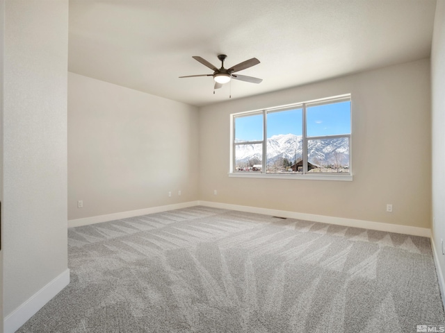 carpeted spare room featuring ceiling fan