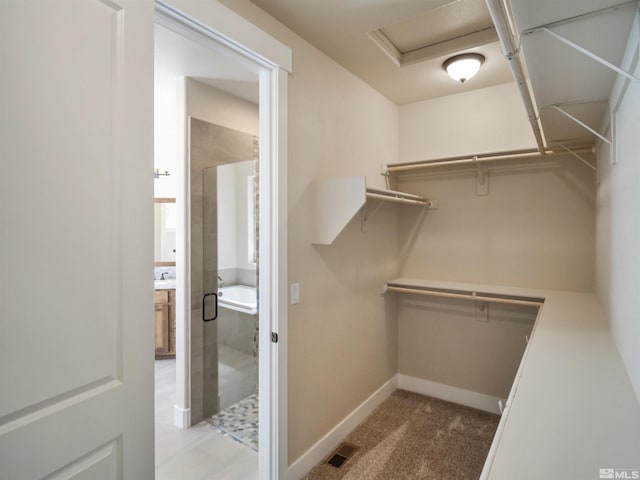 spacious closet with light tile flooring