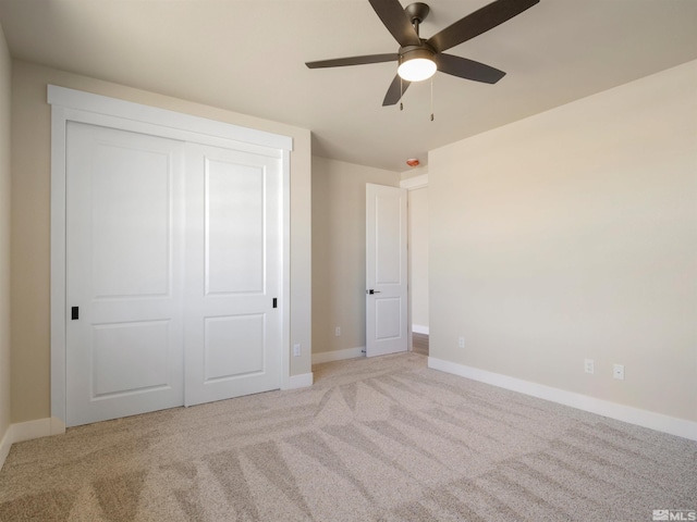 unfurnished bedroom featuring light carpet, a closet, and ceiling fan