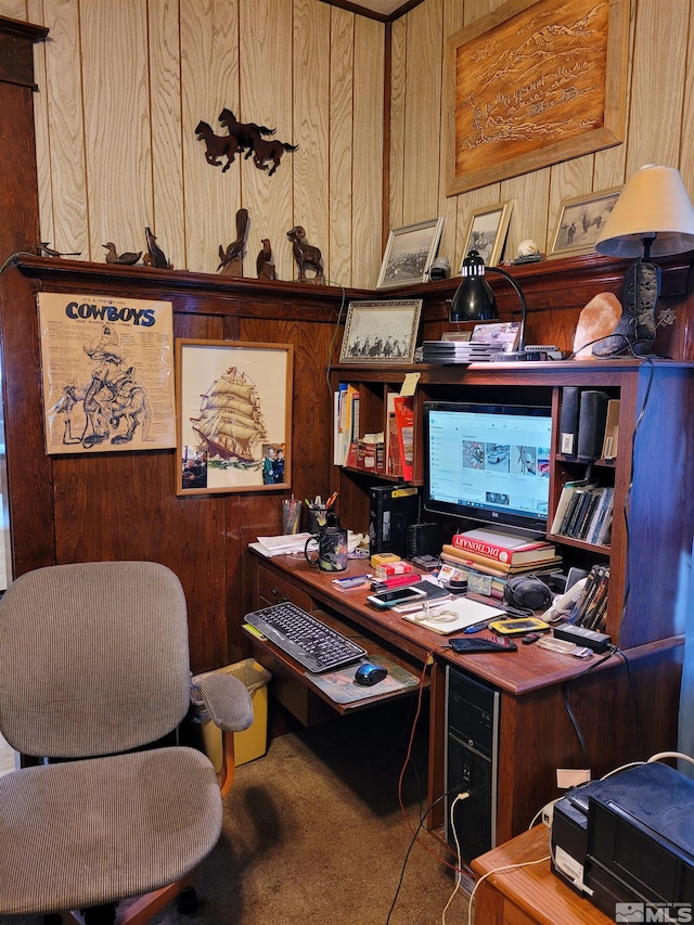 carpeted home office featuring wood walls