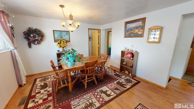 dining area featuring an inviting chandelier and light wood-type flooring