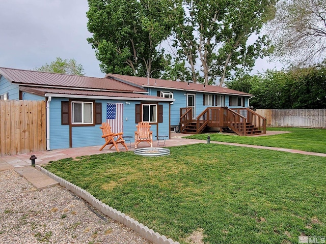 ranch-style house with a fire pit, a deck, and a front yard