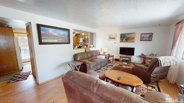 living room featuring light wood-type flooring and a textured ceiling