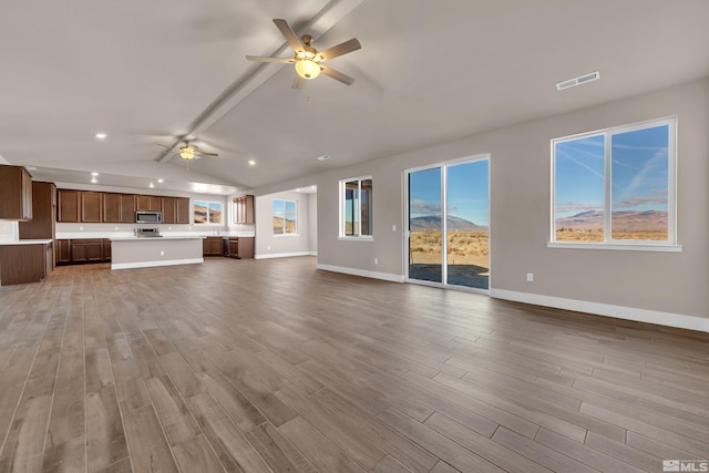 unfurnished living room featuring ceiling fan, lofted ceiling, and hardwood / wood-style floors