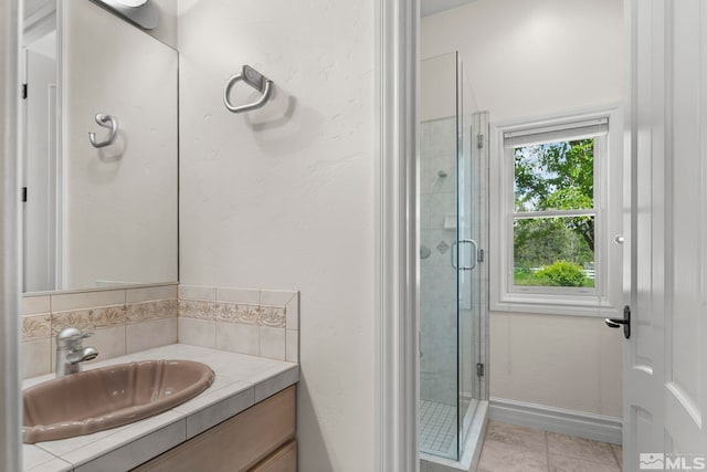 bathroom with tile flooring, a shower with shower door, and vanity with extensive cabinet space