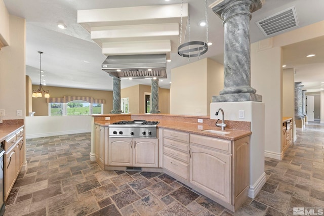 kitchen with dark tile flooring, light brown cabinets, sink, and ornate columns