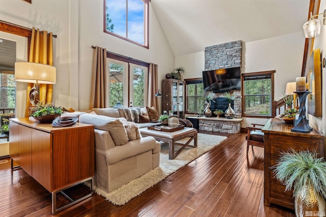 living room featuring high vaulted ceiling, dark wood-type flooring, and a fireplace