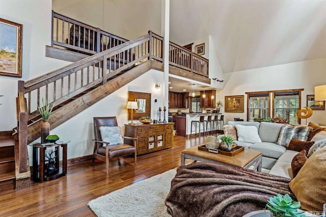 living room with a high ceiling and dark wood-type flooring