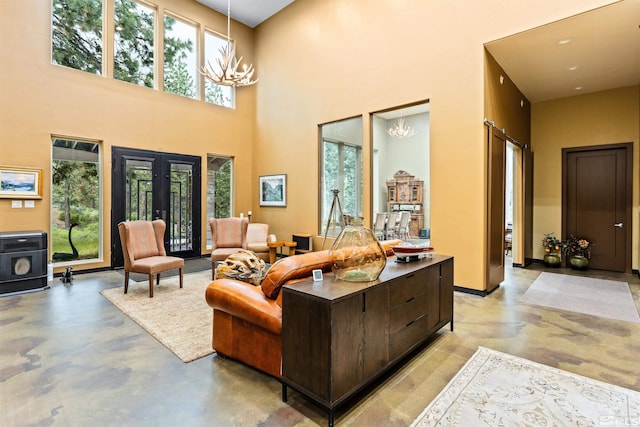 living room with a notable chandelier, a high ceiling, and french doors