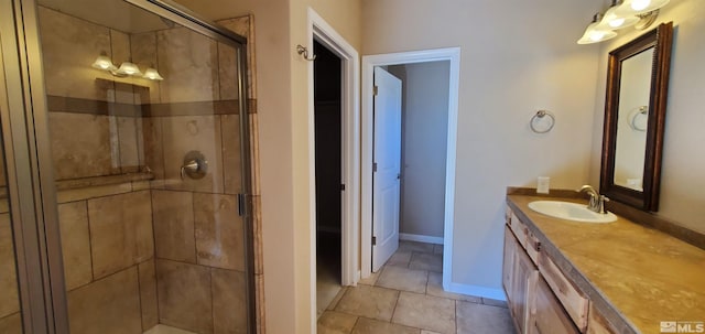 bathroom with tile flooring, a shower with shower door, and oversized vanity