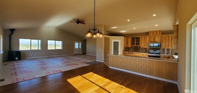 kitchen featuring tasteful backsplash, range, ceiling fan with notable chandelier, high vaulted ceiling, and hardwood / wood-style flooring