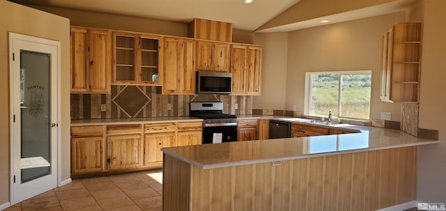 kitchen featuring kitchen peninsula, light tile floors, appliances with stainless steel finishes, backsplash, and vaulted ceiling