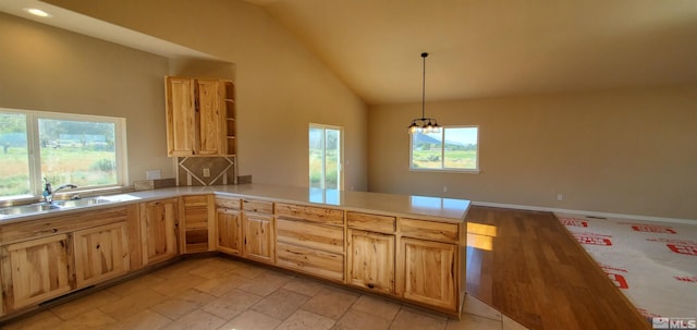 kitchen with a chandelier, pendant lighting, light tile flooring, kitchen peninsula, and sink