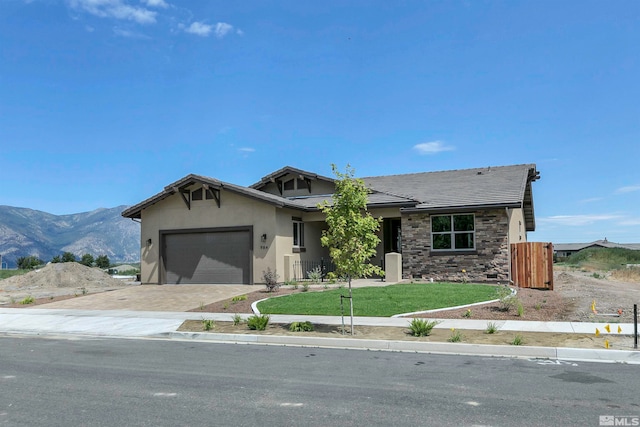 view of front of home featuring a mountain view, a front lawn, and a garage