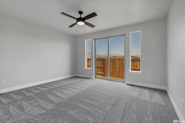 carpeted empty room featuring plenty of natural light and ceiling fan